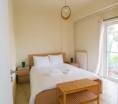 a bedroom with a large white bed and a window at City Garden Escape with a View! in Athens