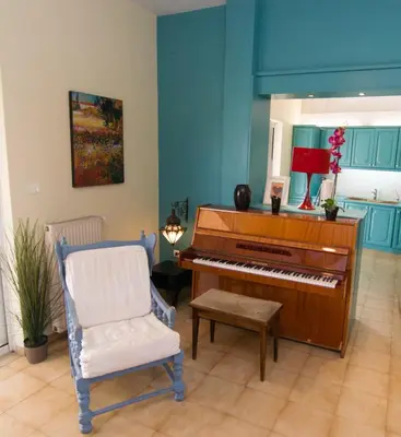a living room with a piano and a chair at City Garden Escape with a View! in Athens