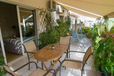 a patio with a wooden table and chairs on a balcony at City Garden Escape with a View! in Athens