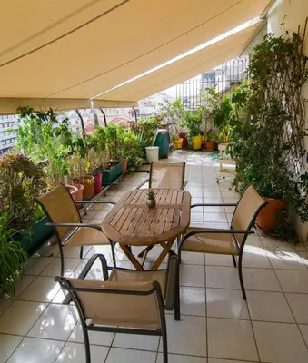 a patio with tables and chairs and potted plants at City Garden Escape with a View! in Athens