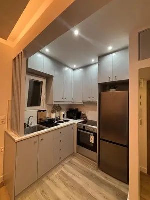 a kitchen with white cabinets and a stainless steel refrigerator at CasaCentrale in Athens