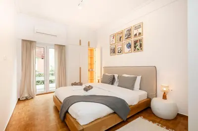 a white bedroom with a large bed and a window at Kallimarmaro Gem II in Athens