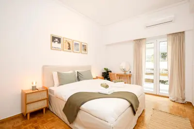 a white bedroom with a large bed and a window at Kallimarmaro Gem II in Athens