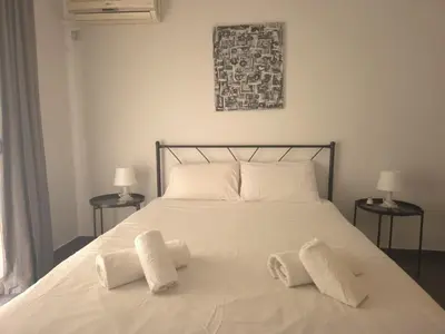 a white bed with two white pillows on it at City Harmony Flat in Athens