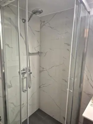 a shower with a glass door in a bathroom at City Harmony Flat in Athens