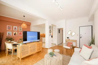 a living room with a television on a wooden cabinet at Kallimarmaro Gem III in Athens