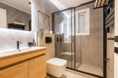 a bathroom with a shower and a toilet and a sink at Kallimarmaro Gem III in Athens