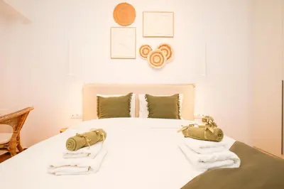 a bedroom with a white bed with towels on it at Kallimarmaro Gem III in Athens