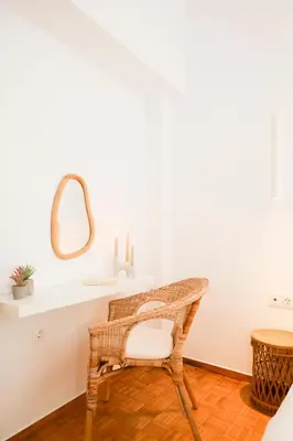 a wicker chair in a bathroom with a mirror at Kallimarmaro Gem III in Athens