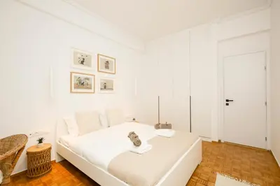 a white bedroom with a large white bed at Kallimarmaro Gem I in Athens