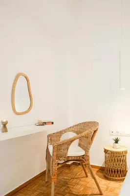 a wicker chair in a room with a mirror at Kallimarmaro Gem I in Athens