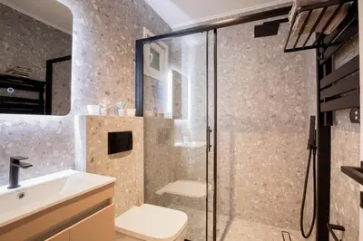 a bathroom with a shower and a toilet and a sink at Kallimarmaro Gem I in Athens