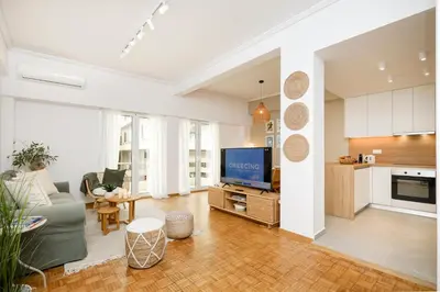 a living room with a couch and a tv at Kallimarmaro Gem I in Athens