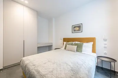a bedroom with a large bed and a table at Piraeus Apartment in Piraeus