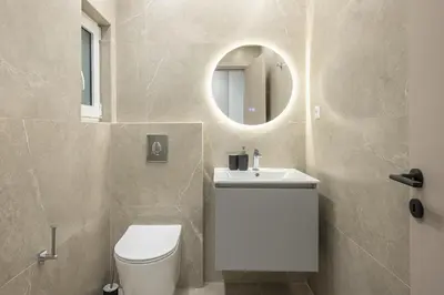a bathroom with a toilet and a sink and a mirror at Piraeus Apartment in Piraeus