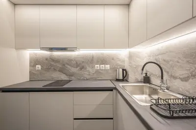 a kitchen with white cabinets and a sink at Piraeus Apartment in Piraeus