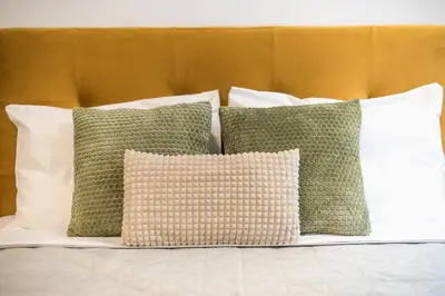 a group of pillows on top of a bed at Piraeus Apartment in Piraeus