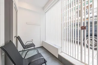 a room with two chairs and a large window at Piraeus Apartment in Piraeus