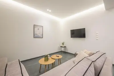 a white living room with a couch and a table at Piraeus Apartment in Piraeus