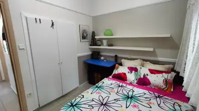 a small bedroom with a bed with colorful pillows at Long-Stay Family & Work Oasis -20 min to Center & Sea in Piraeus