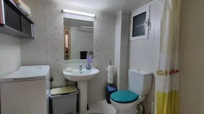 a white bathroom with a sink and a toilet at Long-Stay Family & Work Oasis -20 min to Center & Sea in Piraeus