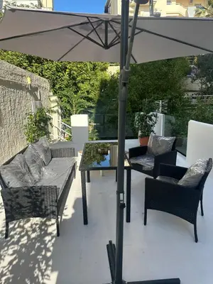 a patio with an umbrella and chairs and a table at JOHNMAR apartment in Athens
