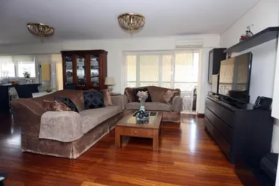 a living room with a couch and a coffee table at Cosy and Comfy near Niarxos and Athens Riviera in Athens