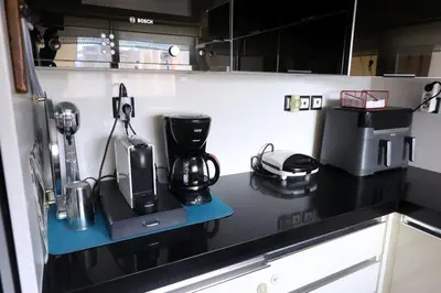 a kitchen with a counter with a coffee maker on it at Cosy and Comfy near Niarxos and Athens Riviera in Athens
