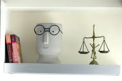 a shelf with a statue of a head with glasses and a scale at Cosy and Comfy near Niarxos and Athens Riviera in Athens