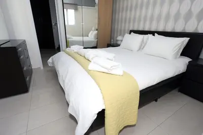 a bedroom with a large bed with towels on it at Cosy and Comfy near Niarxos and Athens Riviera in Athens