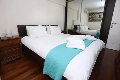 a bedroom with two beds with towels on top of it at Cosy and Comfy near Niarxos and Athens Riviera in Athens