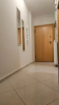 an empty room with a door and a tiled floor at Triton apartment in Athens