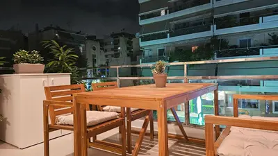 a wooden table and chairs on a balcony at Triton apartment in Athens