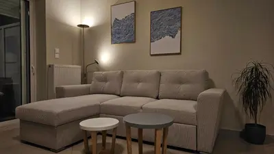 a living room with a couch and two tables at Triton apartment in Athens