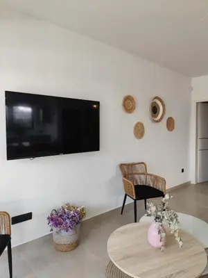 a living room with a tv and a table and chairs at Αriadne in Porto Rafti