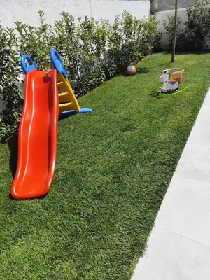 a playground with a plastic slide in the grass at Αriadne in Porto Rafti