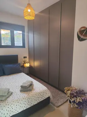 a bedroom with a bed and a large closet at Αriadne in Porto Rafti