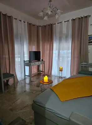 a bedroom with a bed and a desk and a television at Aghia Marina, Aegina Studio in Aegina Town
