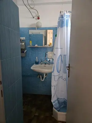 a bathroom with a sink and a shower curtain at Aghia Marina, Aegina Studio in Aegina Town
