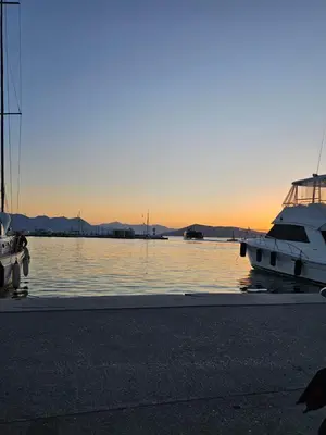 a couple of boats parked in the water at sunset at Aghia Marina, Aegina Studio in Aegina Town