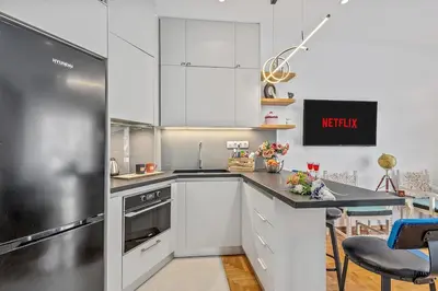 a kitchen with white cabinets and a black counter top at h2h Kalypso #Luxury smART, hi-tec, with parking, in 1'metro in Piraeus