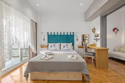 a bedroom with a large bed and a desk at h2h Kalypso #Luxury smART, hi-tec, with parking, in 1'metro in Piraeus