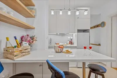 a kitchen with a white counter with two glasses of wine at h2h Erato #Luxury, tech, smART with parking, in 1' metro in Piraeus