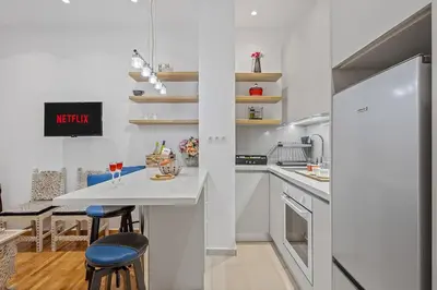 a kitchen with white counters and a table and chairs at h2h Erato #Luxury, tech, smART with parking, in 1' metro in Piraeus