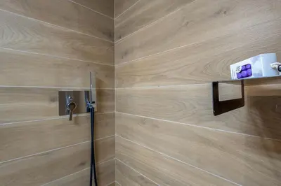 a bathroom with a shower with a wooden wall at h2h Erato #Luxury, tech, smART with parking, in 1' metro in Piraeus