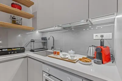 a white kitchen with a counter top with a tray of food at h2h Erato #Luxury, tech, smART with parking, in 1' metro in Piraeus