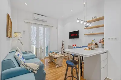 a living room with a blue couch and a table at h2h Erato #Luxury, tech, smART with parking, in 1' metro in Piraeus