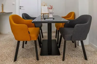 a dining table with orange chairs and a black table at Nikiou 11 in Athens