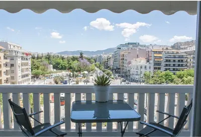 a table and chairs on a balcony with a view of a city at Athens view suite in Athens