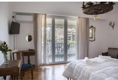 a bedroom with a bed and a view of a balcony at Athens view suite in Athens